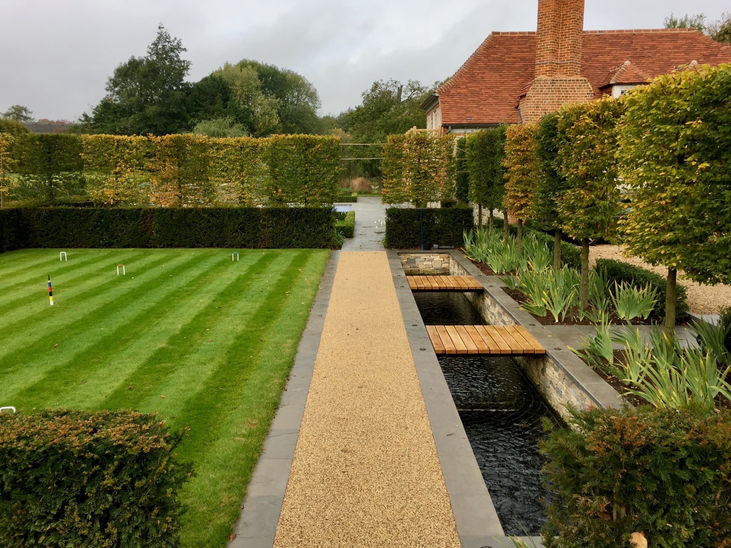 Formal garden with water rill, croquet lawn and pleached hornbeam trees
